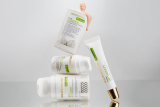 Set of skincare products with visible branding on a reflective surface.